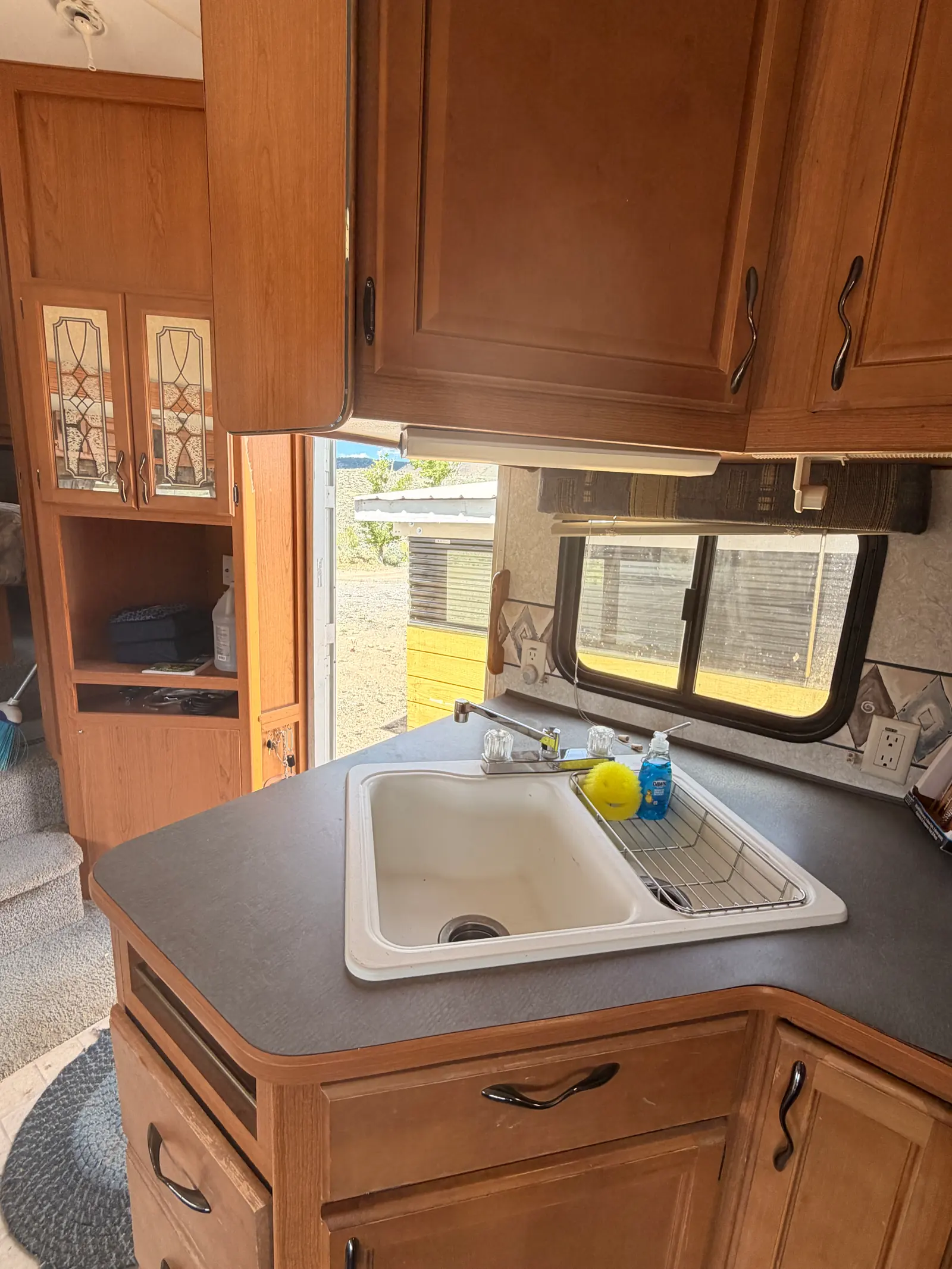 Kitchen sink with a dish rack, running water and a window over the counter