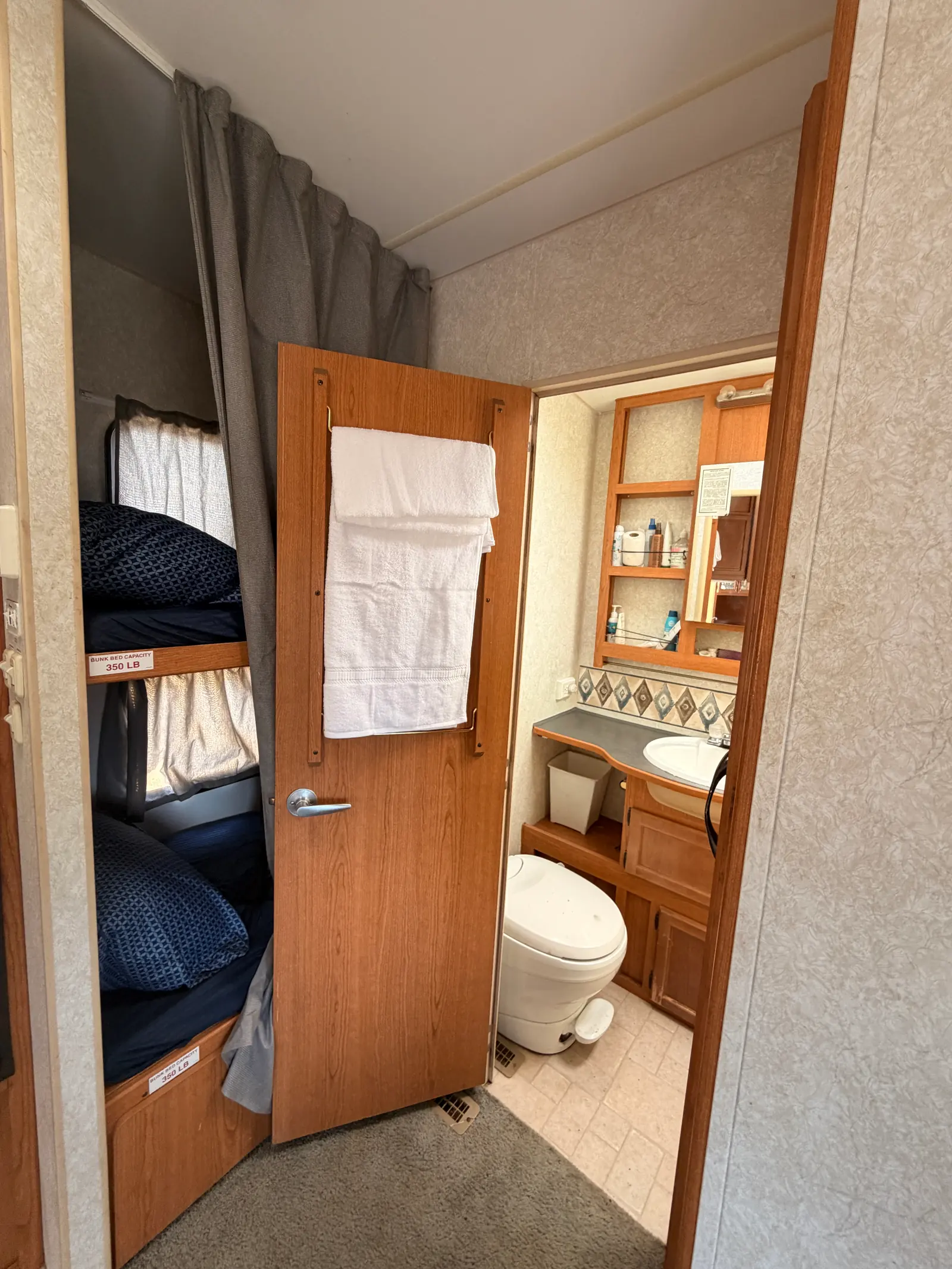 Fresh towels folded over the bathroom door rail, supplied with every rental